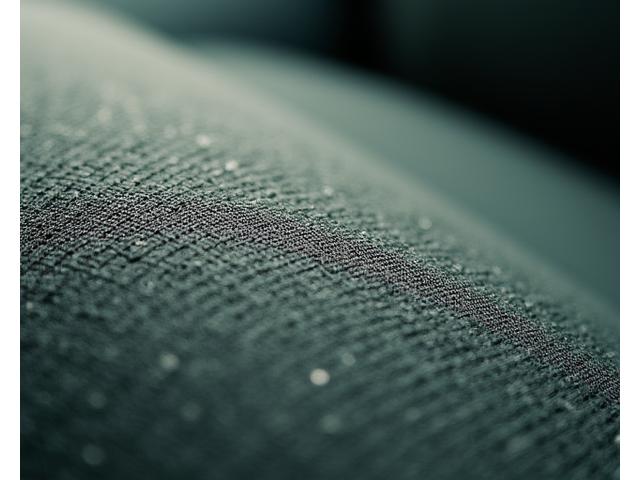 Close-up of luxury car interior upholstery made from sustainable, recycled fabric with a soft, inviting texture.