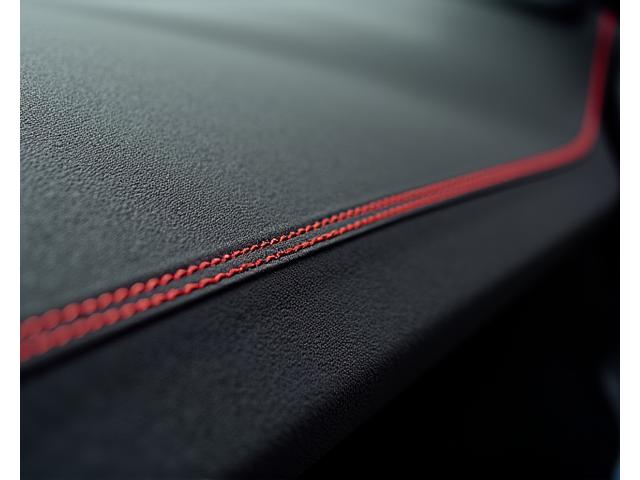 Alcantara dashboard with subtle contrast stitching, reflecting sporty luxury.